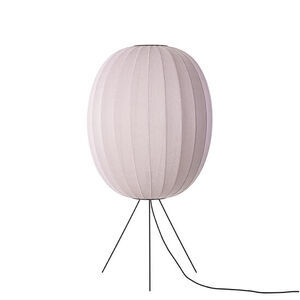 Oval lampe i lys pink med strikket overflade, stående på tre ben.